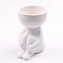 Vaso Decorativo de Cerâmica em formato de figura sentada, ideal para decoração elegante.