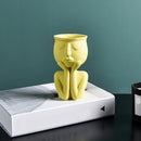 Vaso Decorativo de Cerâmica amarelo com design elegante em cima de uma mesa.