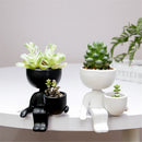Vaso Decorativo de Cerâmica com plantas suculentas em molduras de figuras sentadas.
